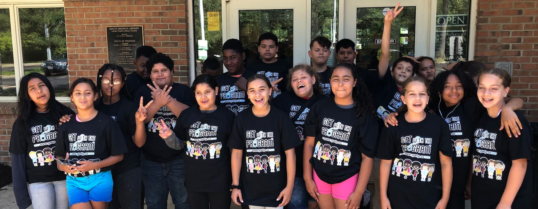 A group of camp participants in front of a library building.