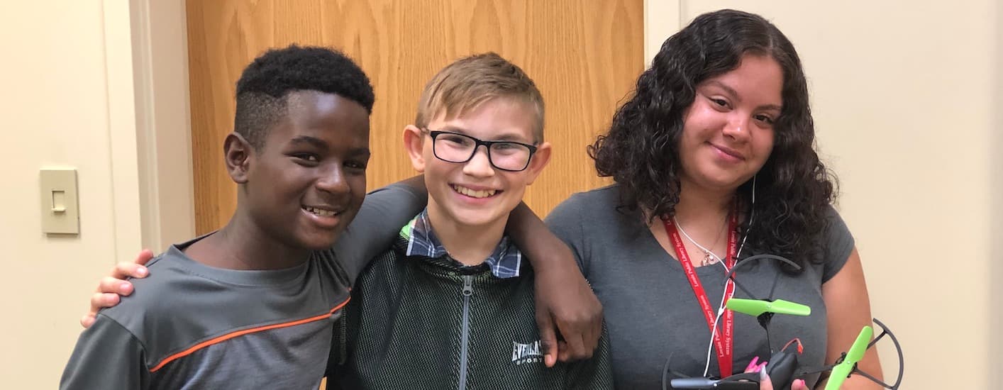 Three participants smiling at a drone camp.