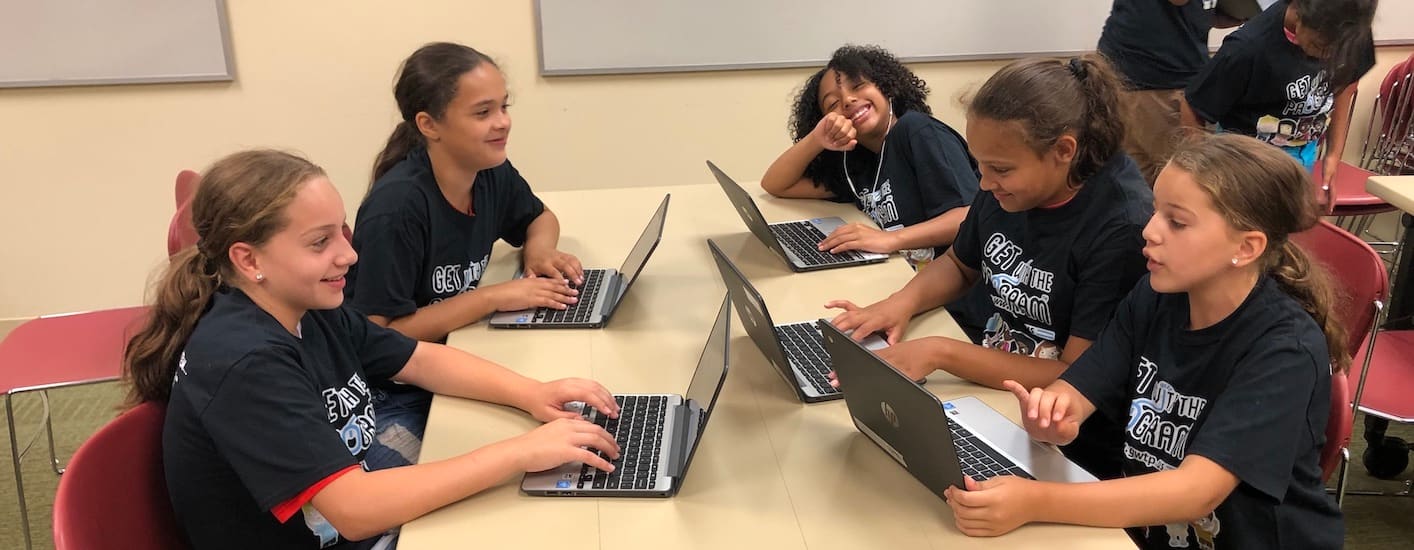 コーディングキャンプ参加者の女の子たちがパソコンに向かってプロジェクトに取り組んでいる。