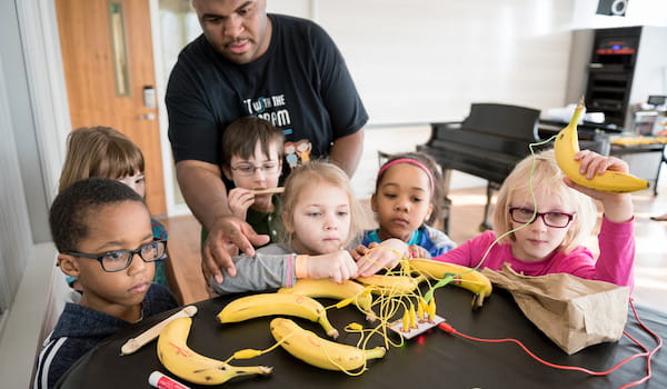 Jason Williams and camp participants playing the banana piano